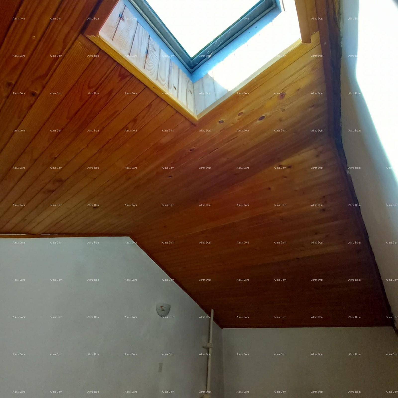 Dachboden mit Holzverkleidung an der Decke und einem Dachfenster.