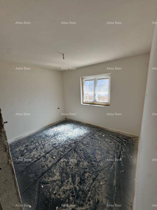 Weiteres unfertiges Schlafzimmer mit einem Fenster und vorbereitetem Bodenbelag für den Ausbau.