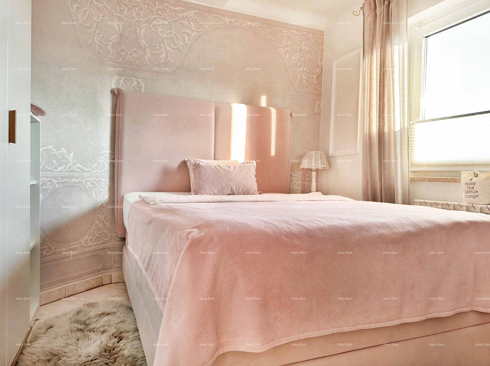 Helles Schlafzimmer mit rosa Bett, dekorativer Wandgestaltung und Fenster.