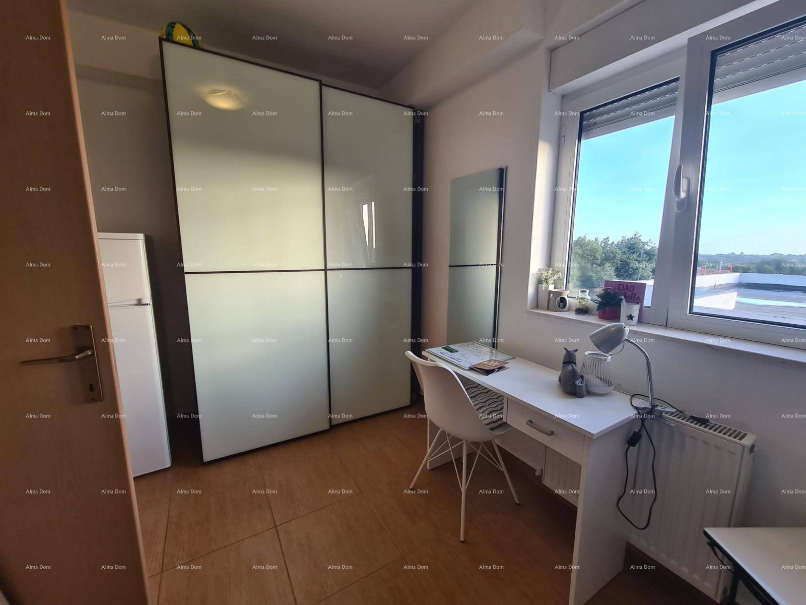 Helles Schlafzimmer mit Schreibtisch, großem Fenster und Einbauschränken.