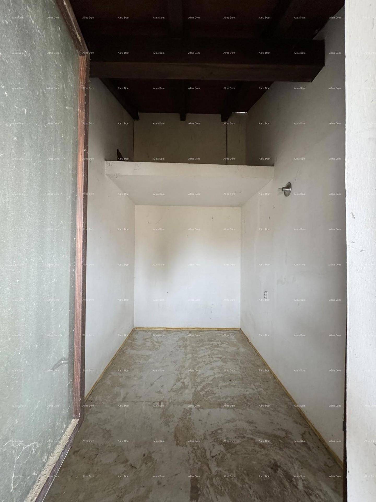 Leerer, unfertiger Raum mit Holzbalken an der Decke, der auf den Innenausbau wartet.