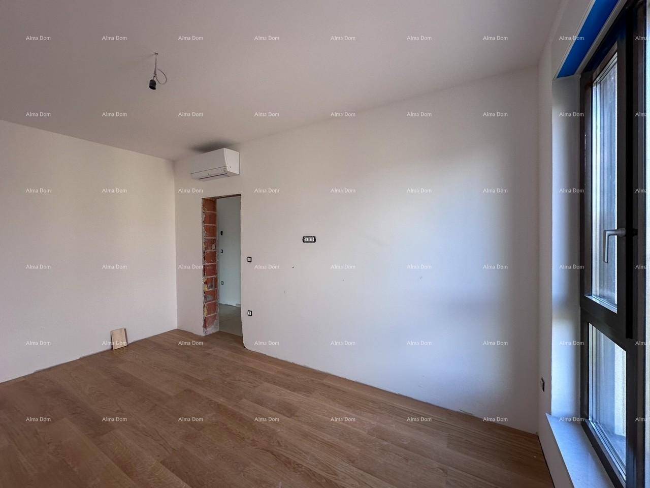 Unfertiges Schlafzimmer mit Holzboden, Klimaanlage und Blick auf den Flur.