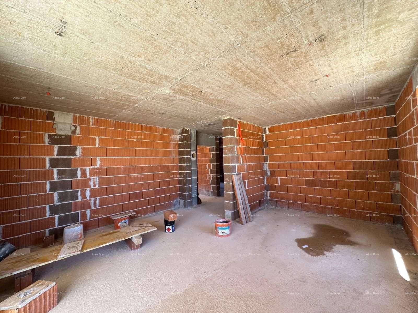 Rohbau eines Innenraums mit unverputzten Ziegelwänden und Betonboden.