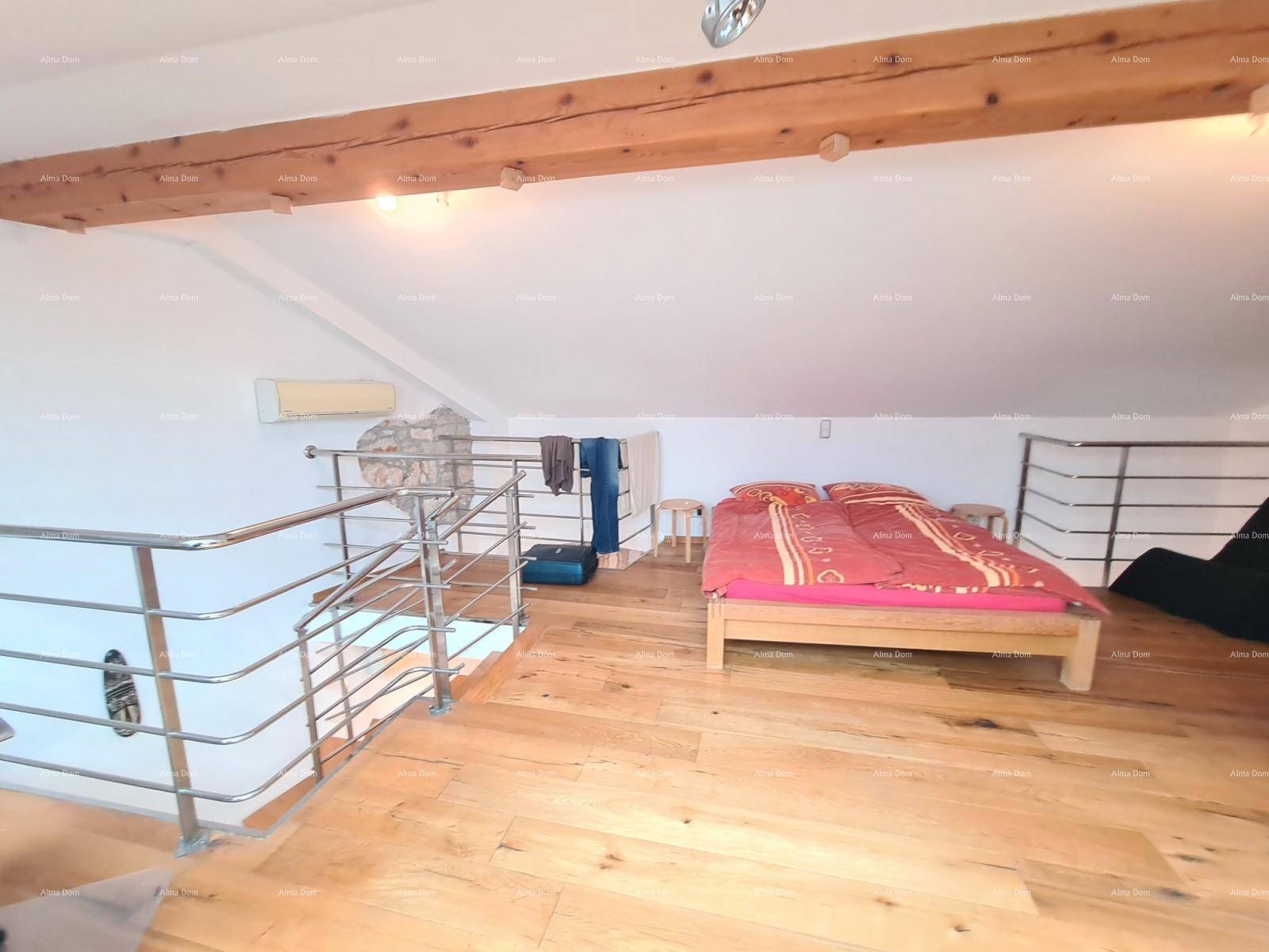 Gemütliches Schlafzimmer im Dachgeschoss mit sichtbaren Holzbalken und Holzboden.