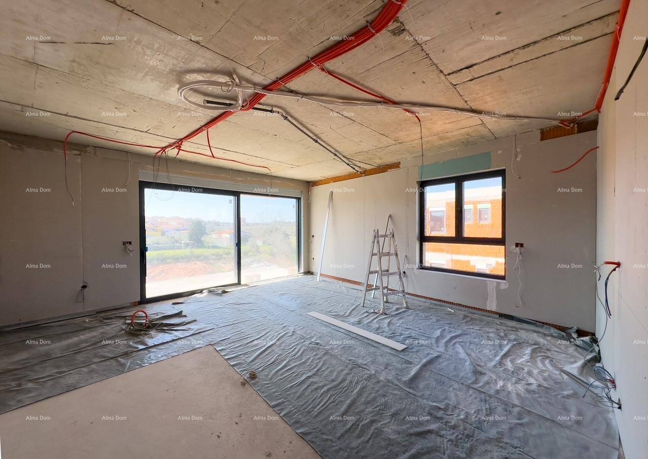 Großer Rohbau-Wohnraum mit Schiebetür zum Balkon und einem weiteren Fenster, der Boden ist abgedeckt.