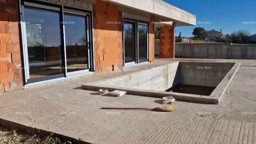 Rohbau mit großen Schiebetüren, Betonterrasse und dem vorbereiteten Bereich für einen Pool.