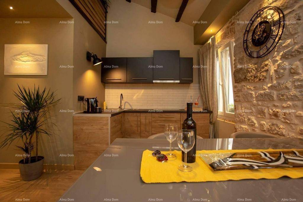 Stilvolle Küche und Essbereich mit gedecktem Tisch, rustikaler Steinwand und modernen schwarzen Hängeschränken.