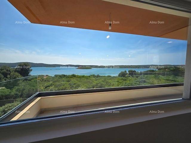 Große Glasschiebetüren öffnen sich zu einem Balkon mit weitem Blick auf das glitzernde Meer.