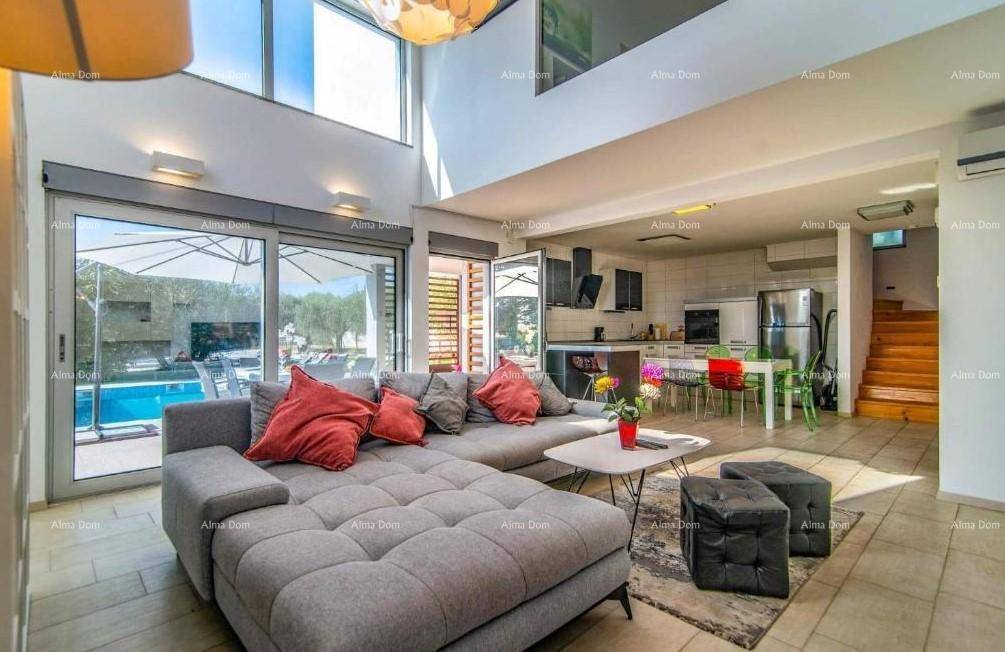 Offener Wohn- und Essbereich mit moderner Küche, großem Sofa und Blick auf den Pool.