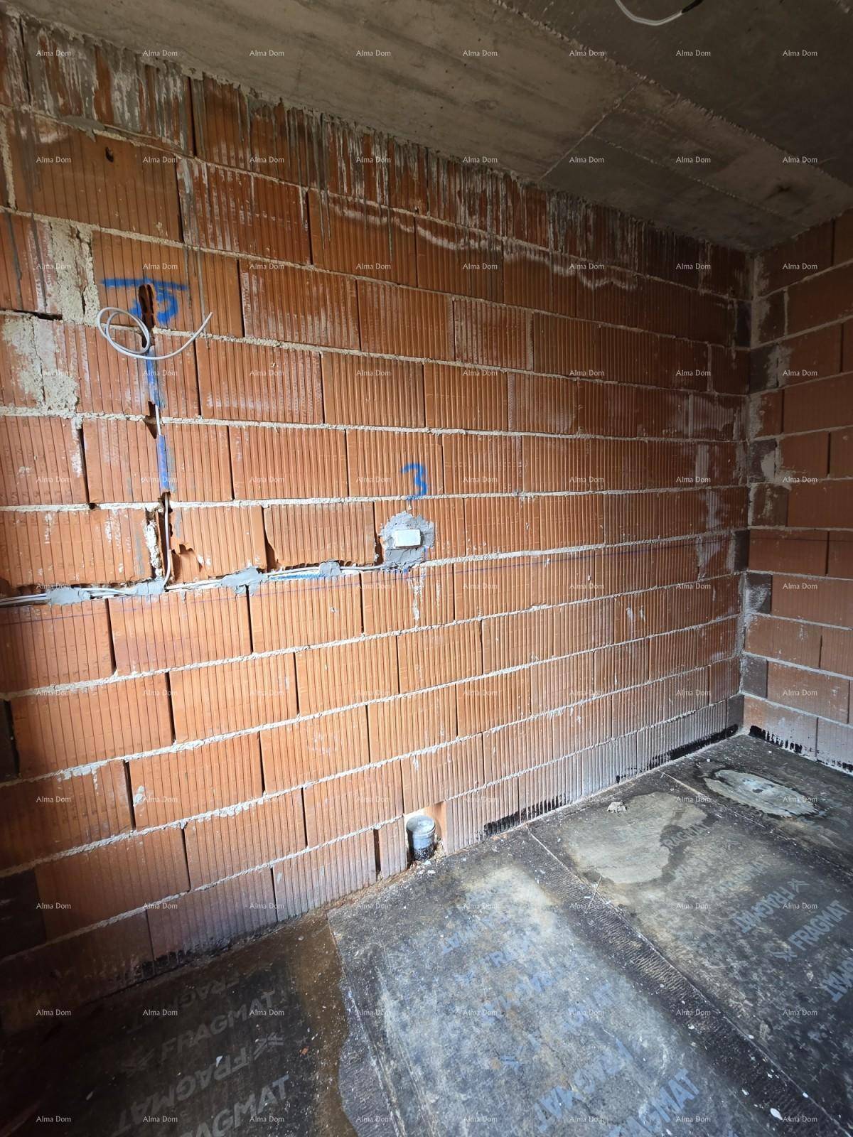 Ecke eines Raumes im Rohbau mit Ziegelwänden und vorbereiteten Elektroinstallationen für Sanitär.