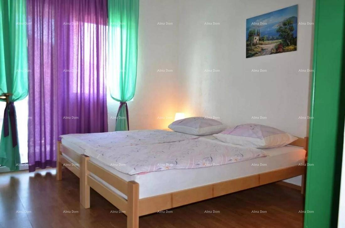 Schlafzimmer mit zwei Einzelbetten, Holzrahmen und farbenfrohen Vorhängen.