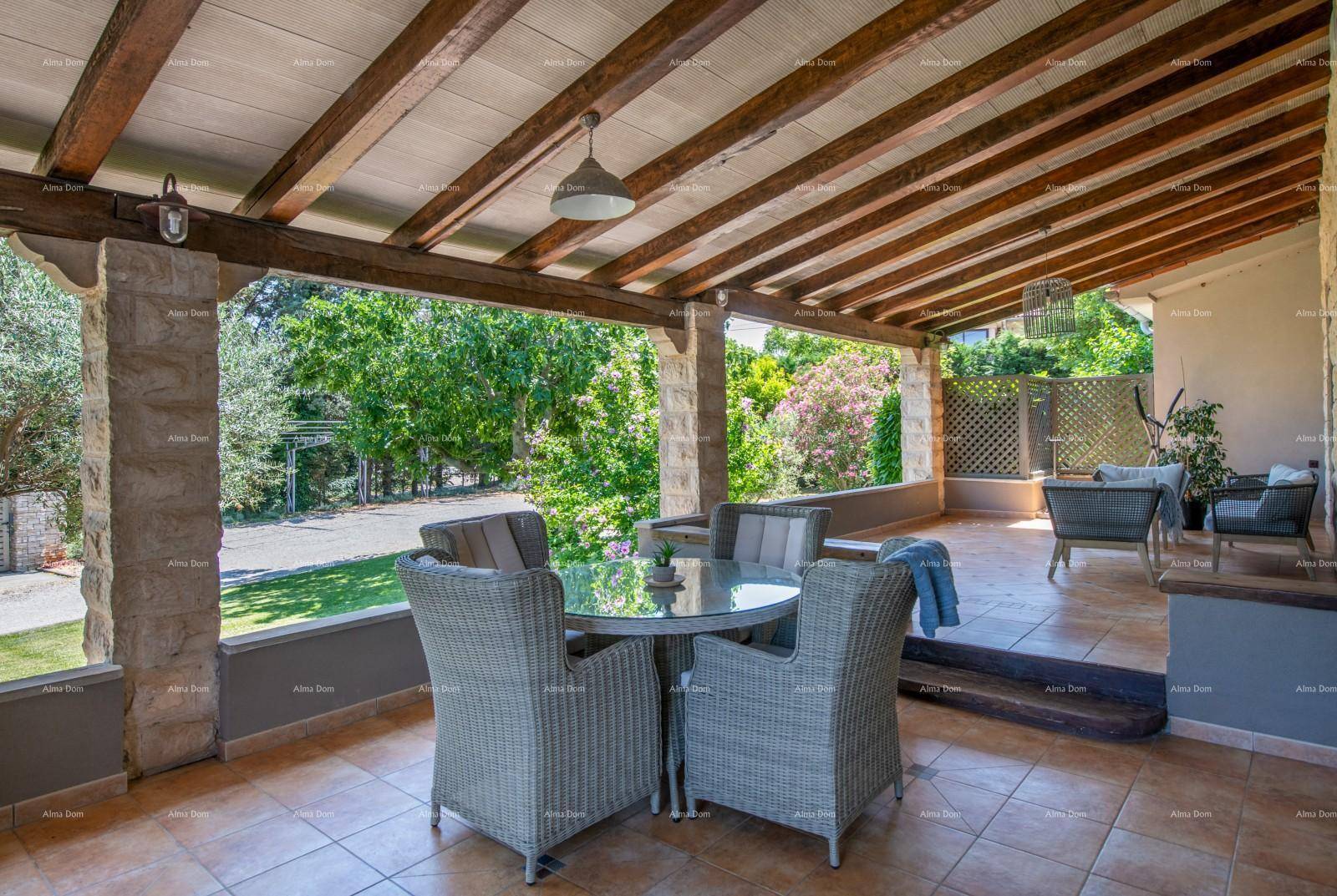 Gemütliche überdachte Terrasse mit Korbmöbeln und Blick ins Grüne.