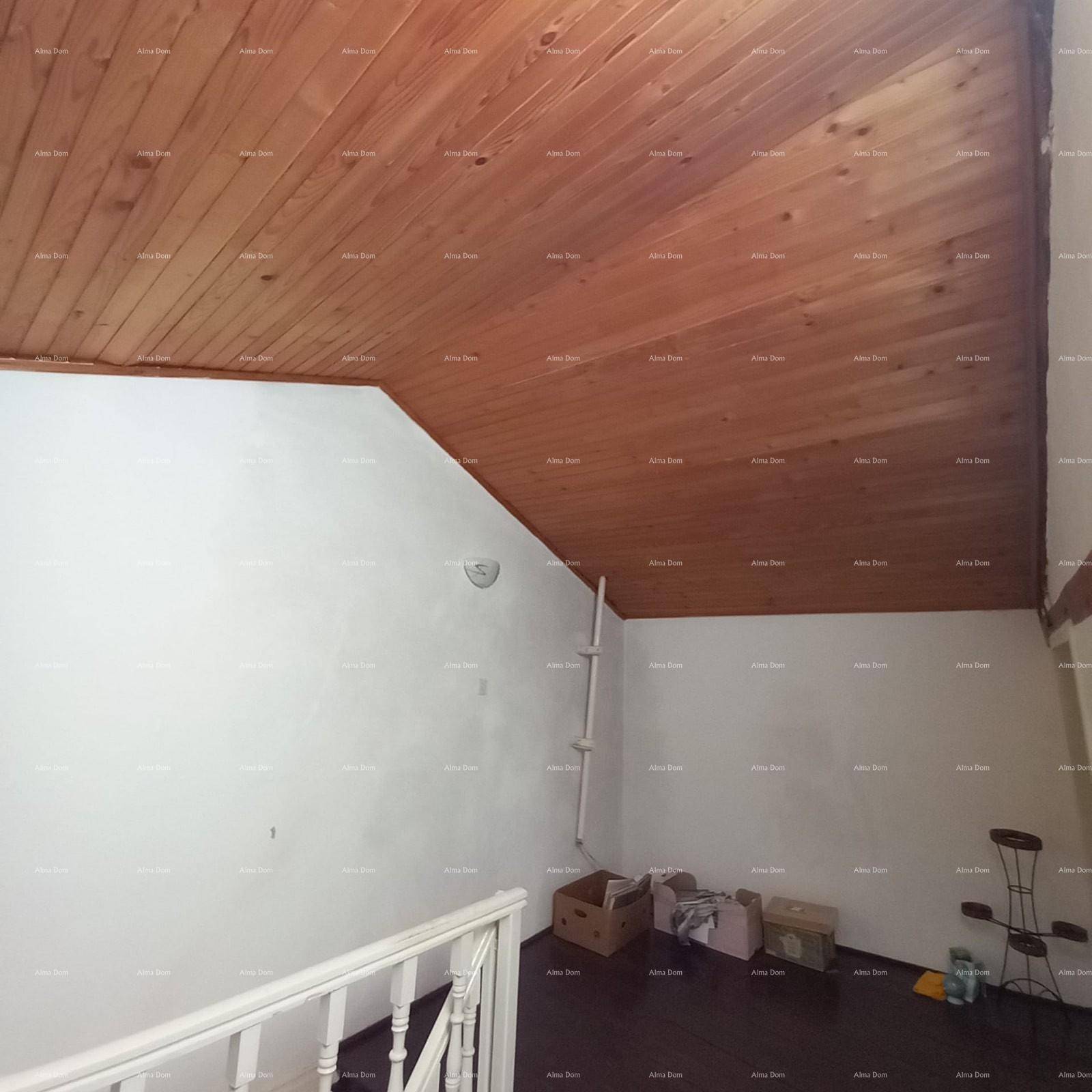 Treppenaufgang mit Holzgeländer und schräger Holzdecke.