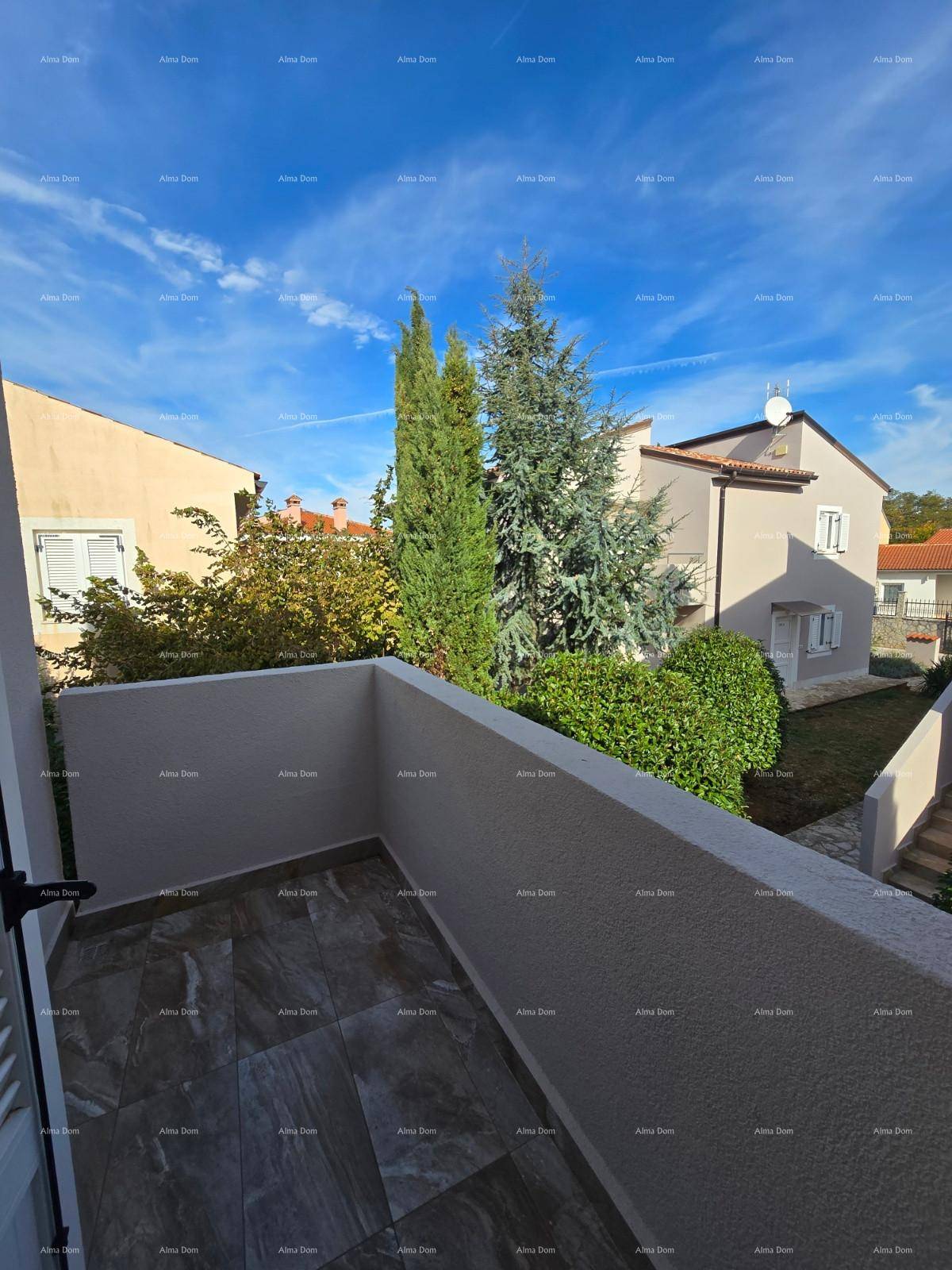 Balkon mit Fliesenboden und Ausblick auf Bäume und benachbarte Gebäude.