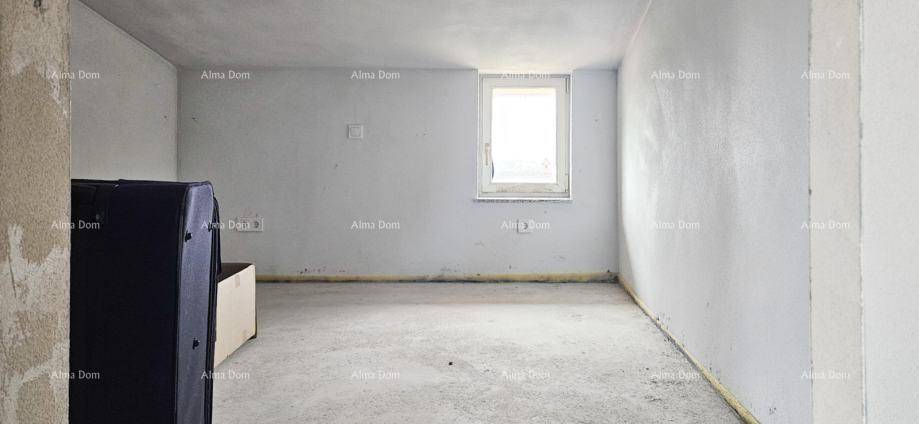 Unfertiger Raum mit einem Fenster und Betonboden, der auf den weiteren Ausbau wartet.