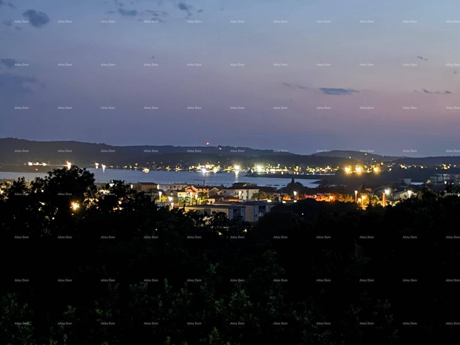 Panoramablick auf die beleuchtete Küstenlinie und die Stadt bei Nacht, mit vielen Lichtern.