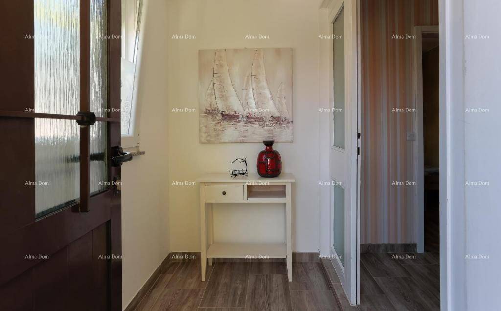 Heller Eingangsbereich mit Holzboden, Konsole und dekorativem Segelbild an der Wand.