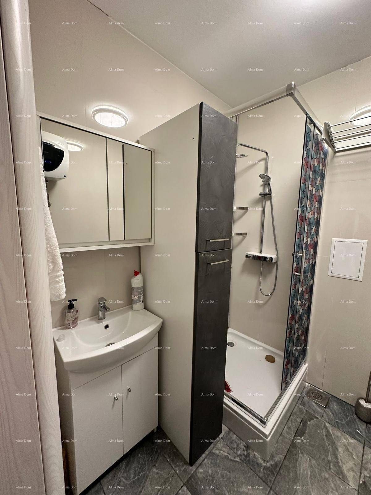 Modernes Badezimmer mit Waschbecken, Spiegelschrank und einer Duschkabine.