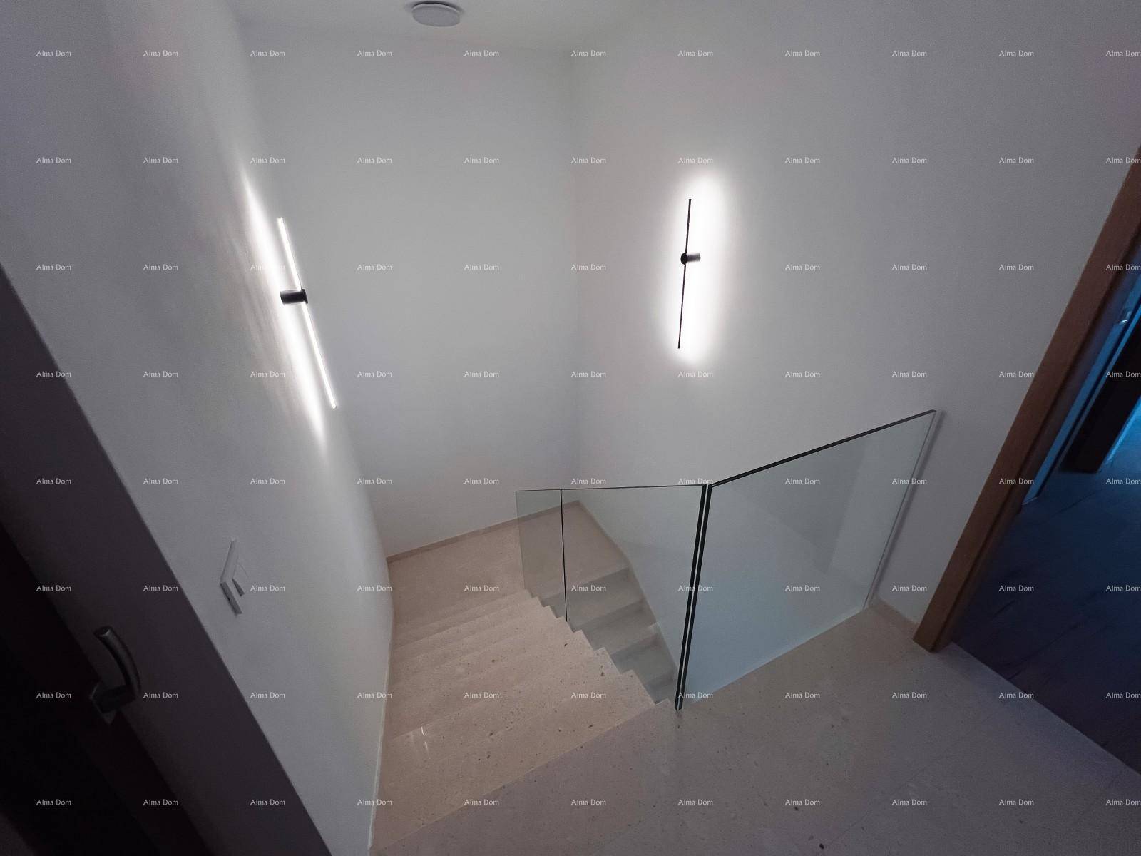 Modernes Treppenhaus mit minimalistischen Wandleuchten und eleganter Glasbrüstung, die ein offenes Gefühl vermittelt.