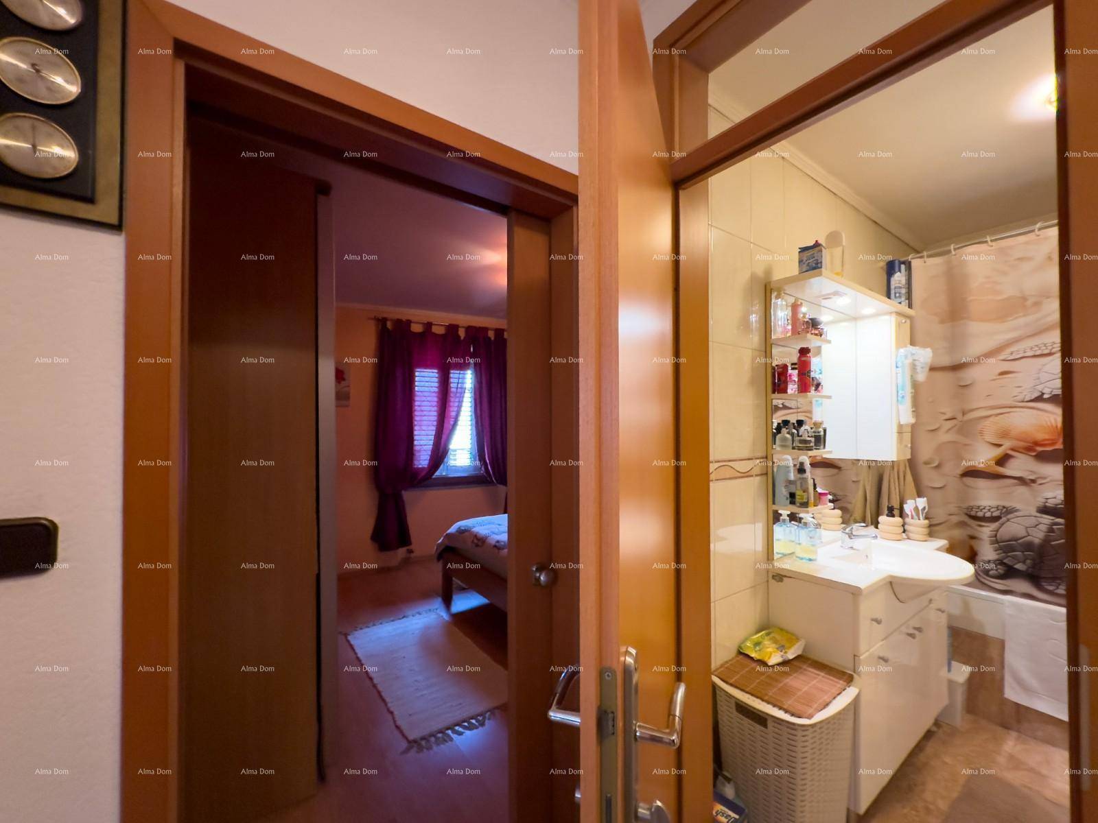 Blick durch eine Tür in ein Badezimmer mit Fliesen und Waschbecken.