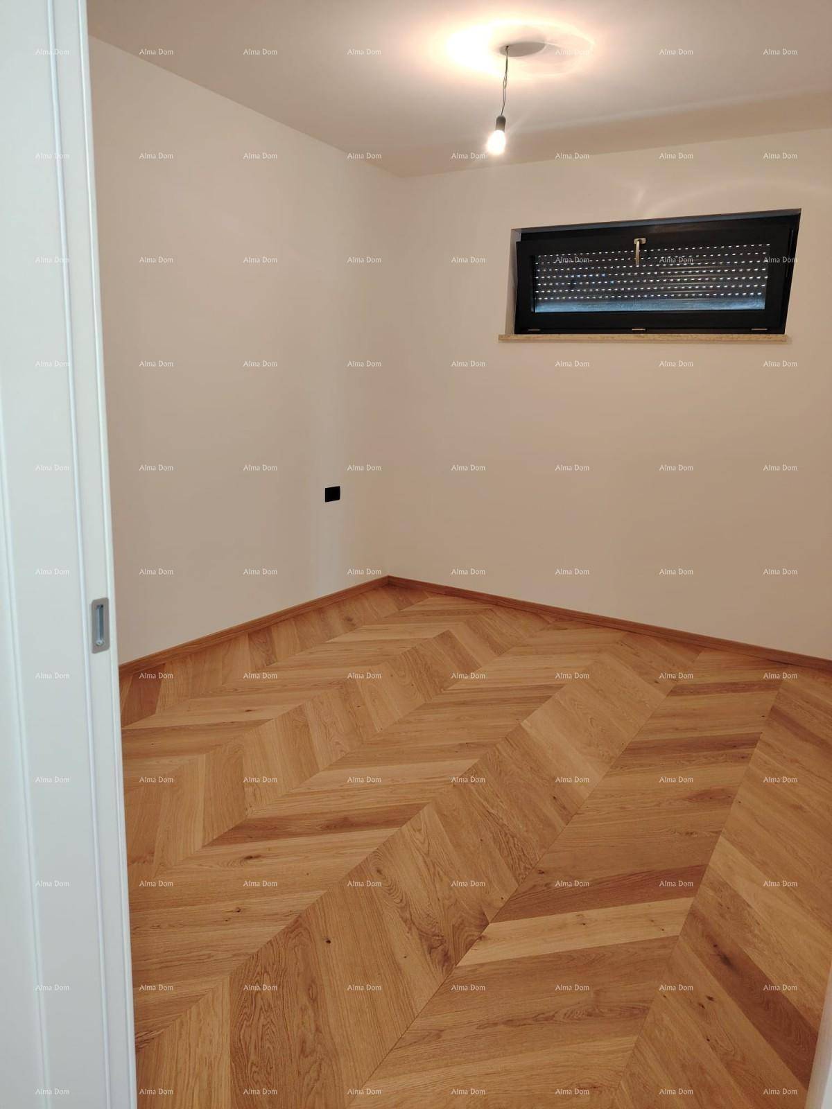 Unmöbliertes Zimmer mit elegantem Fischgrätparkett und Fenster mit Rollladen, ideal als Schlafzimmer.