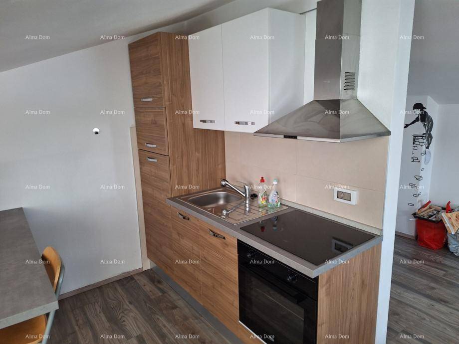 Moderne Küchenzeile mit Holz- und weißen Schränken, Induktionskochfeld und Dunstabzugshaube unter einer Dachschräge.
