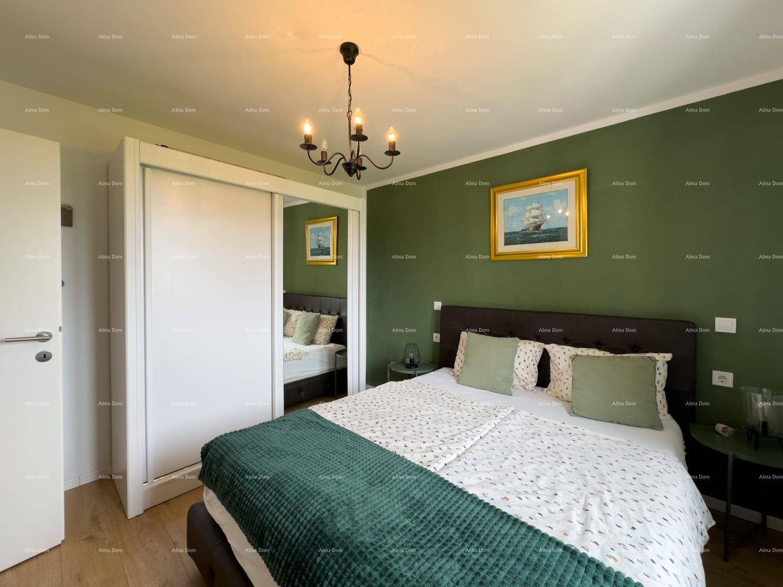 Helles Schlafzimmer mit Doppelbett, grüner Akzentwand und großem Spiegelschrank.