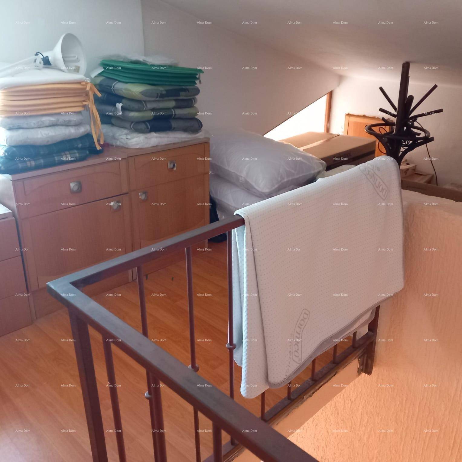 Dachbodenbereich mit Holzboden, Stauraum und schrägen Wänden unter dem Dach.