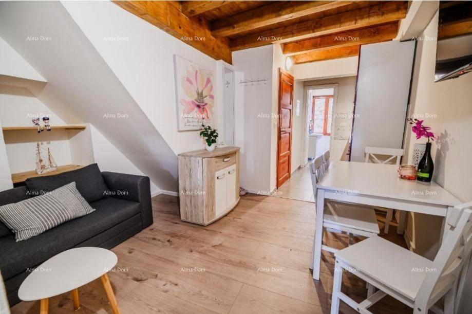 Wohnbereich mit Esstisch, Sofa und rustikalen Holzbalken an der Decke.