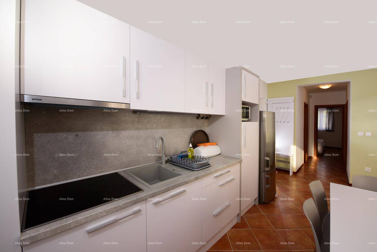 Moderne Küche mit weißen Schränken, Induktionskochfeld und Kühlschrank.