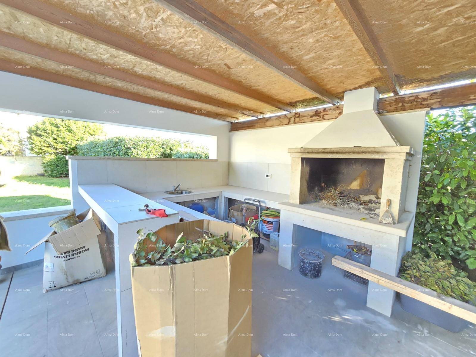 Überdachte Außenküche mit Grillbereich und Arbeitsflächen im Freien.