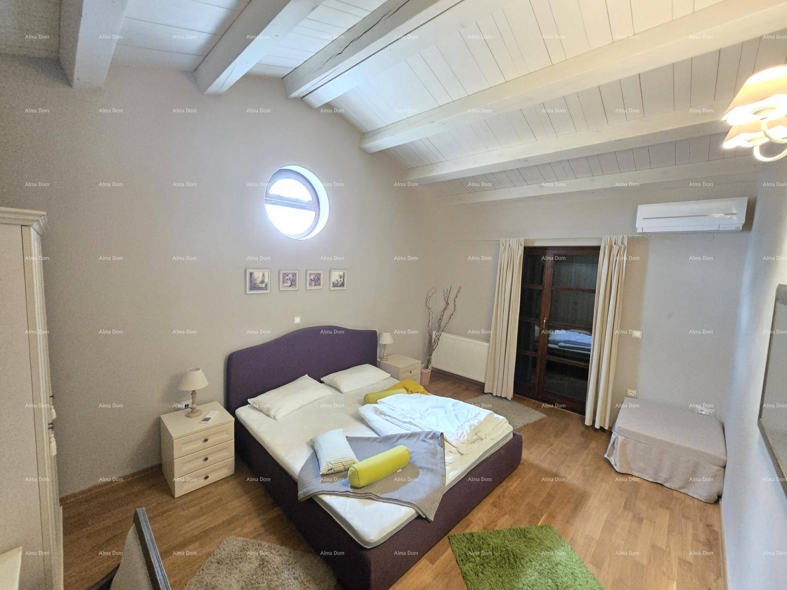 Helles Schlafzimmer mit Doppelbett, runden Fenstern, Klimaanlage und Holzbalkendecke.