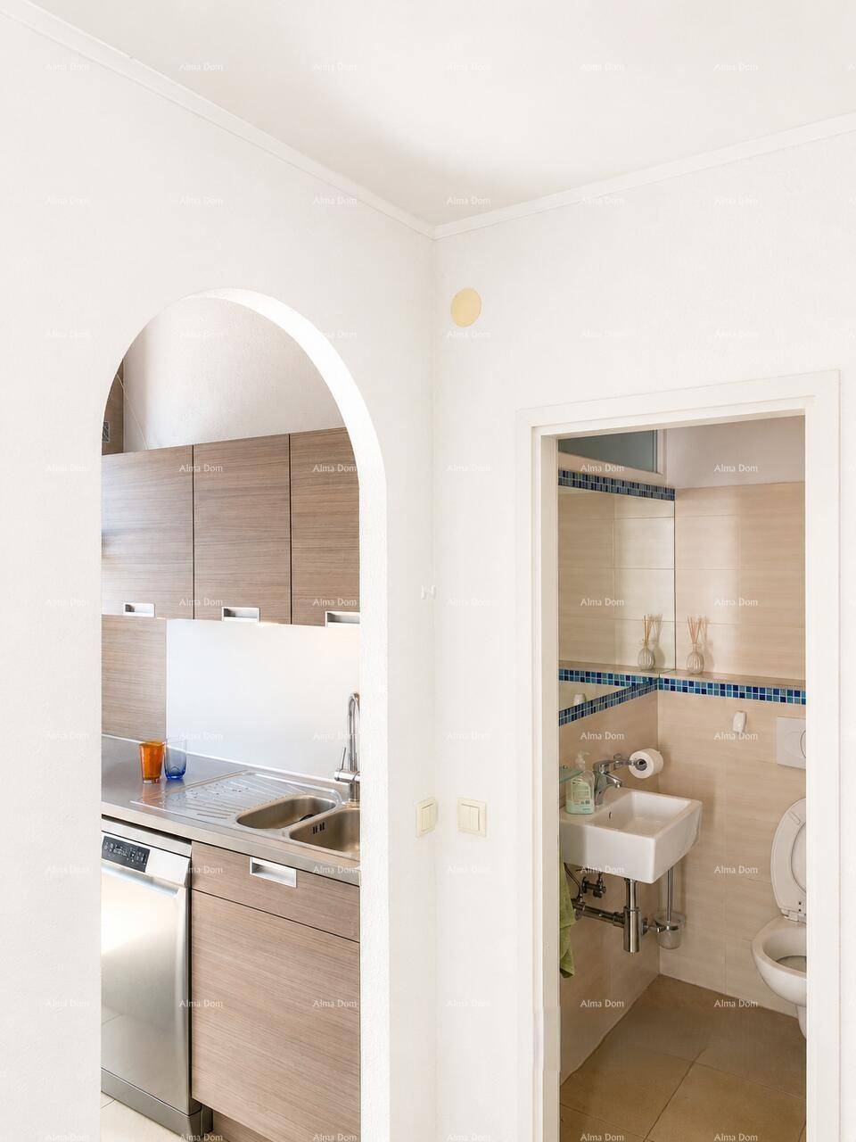 Bereich mit Blick auf eine moderne Küche und den Eingang zu einem Gäste-WC.