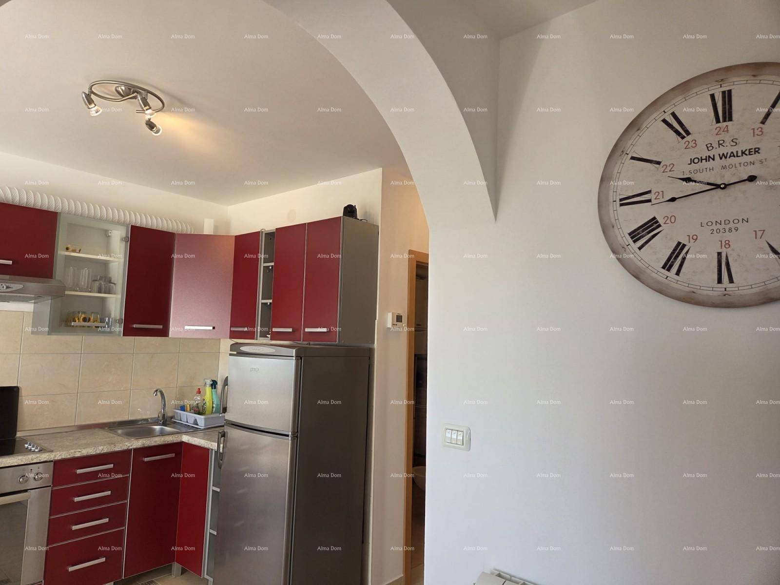 Küche mit roten Schränken, Spüle und einem großen Wanduhr-Dekor.