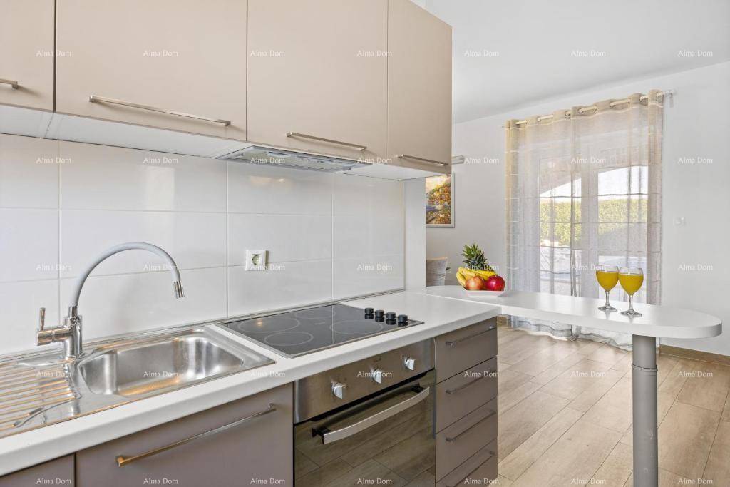 Moderne Küche mit beigen Schränken, Induktionskochfeld und Frühstücksbar.