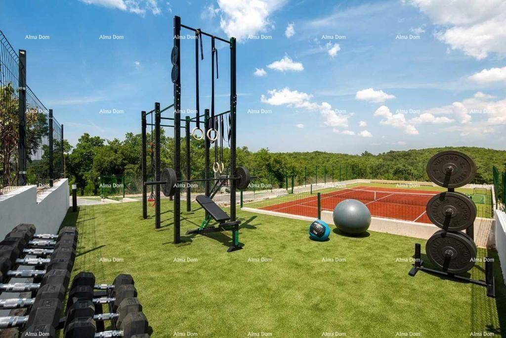 Umfassender Outdoor-Fitnessbereich mit Hanteln und Geräten neben dem Tennisplatz.