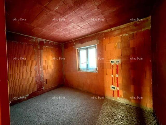 Rohbau eines Zimmers mit Ziegelwänden und einem Fenster, bereit für den Ausbau.