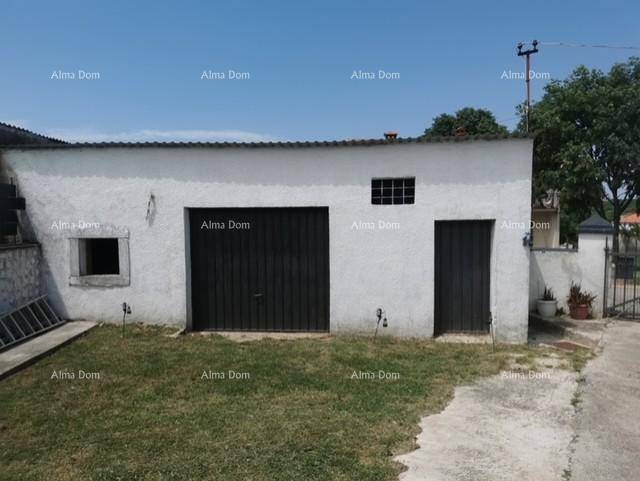 Geräumige Garage mit zwei großen Toren und einem kleinen Fenster, umgeben von Rasen.