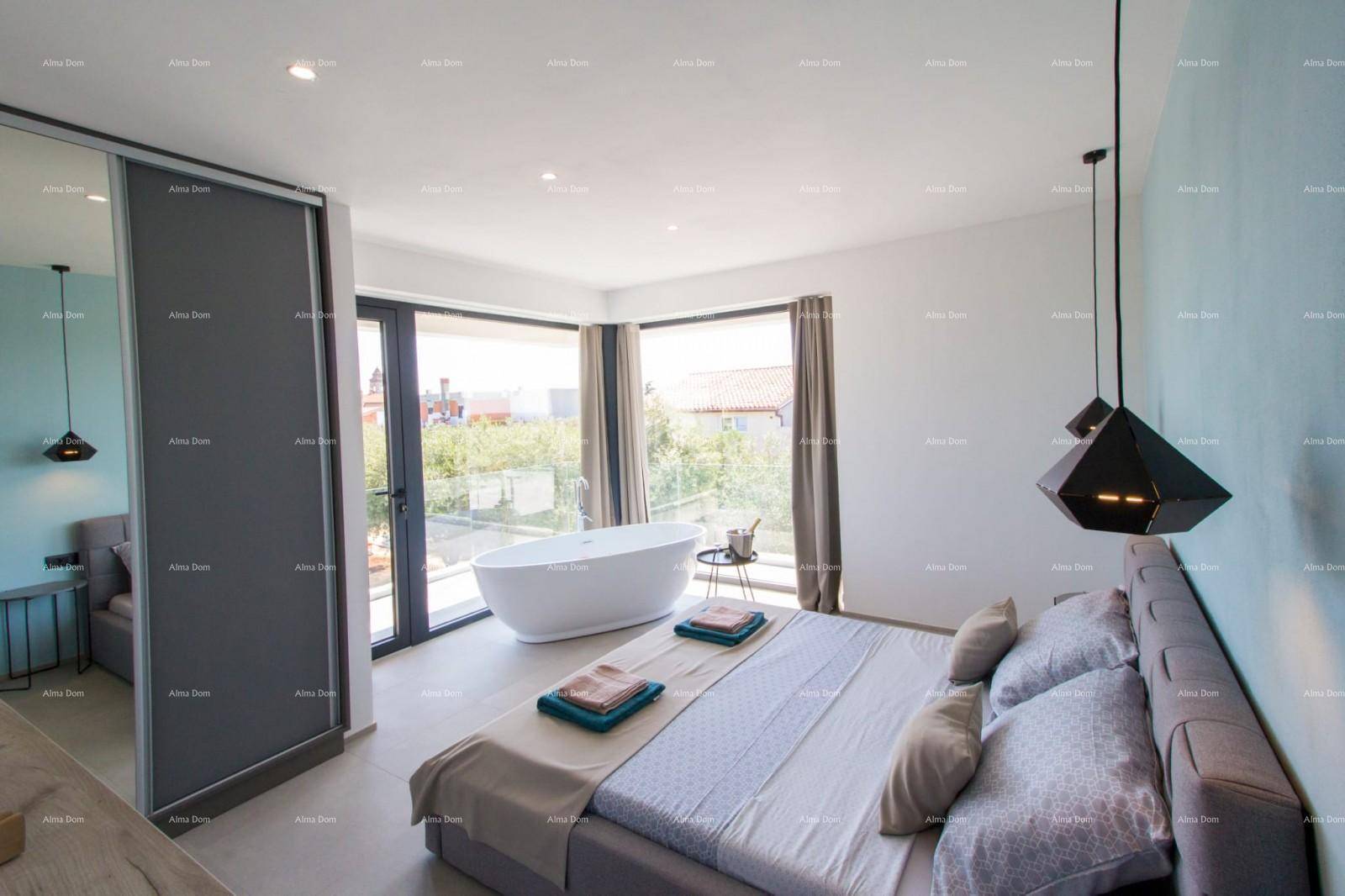 Helles Schlafzimmer mit freistehender Badewanne, großen Fenstern und modernem Bett.