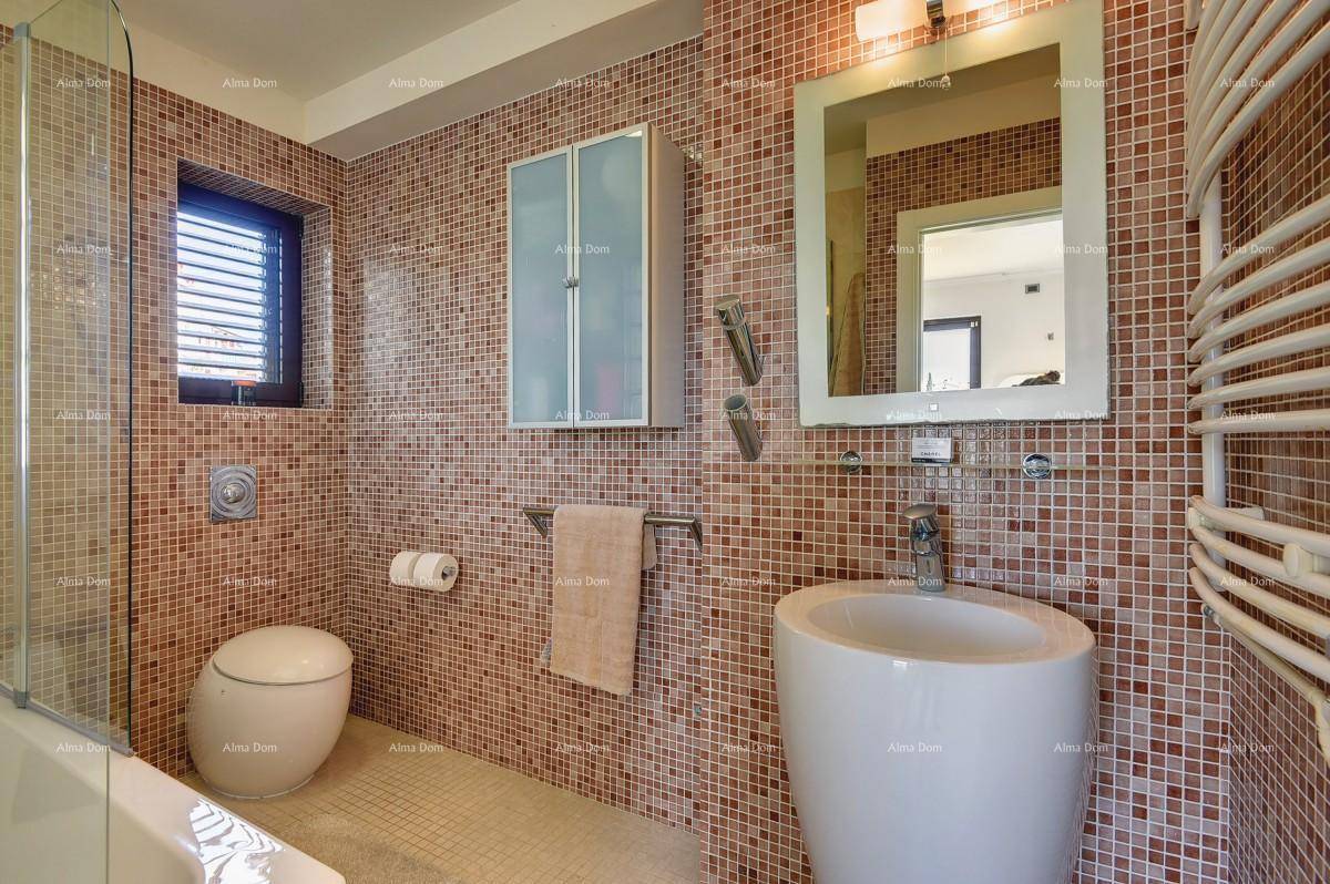 Badezimmer mit kleinen braunen Mosaikfliesen, wandhängendem WC und modernem Waschbecken.