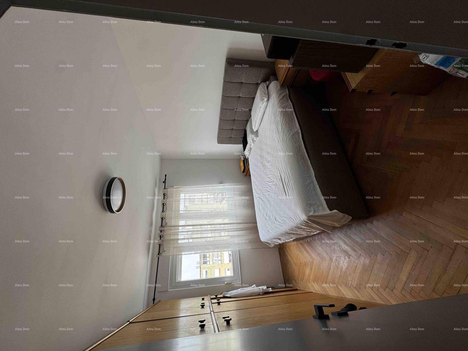 Schlafzimmer mit Doppelbett, Holzboden und Fenster, das natürliches Licht hereinlässt.