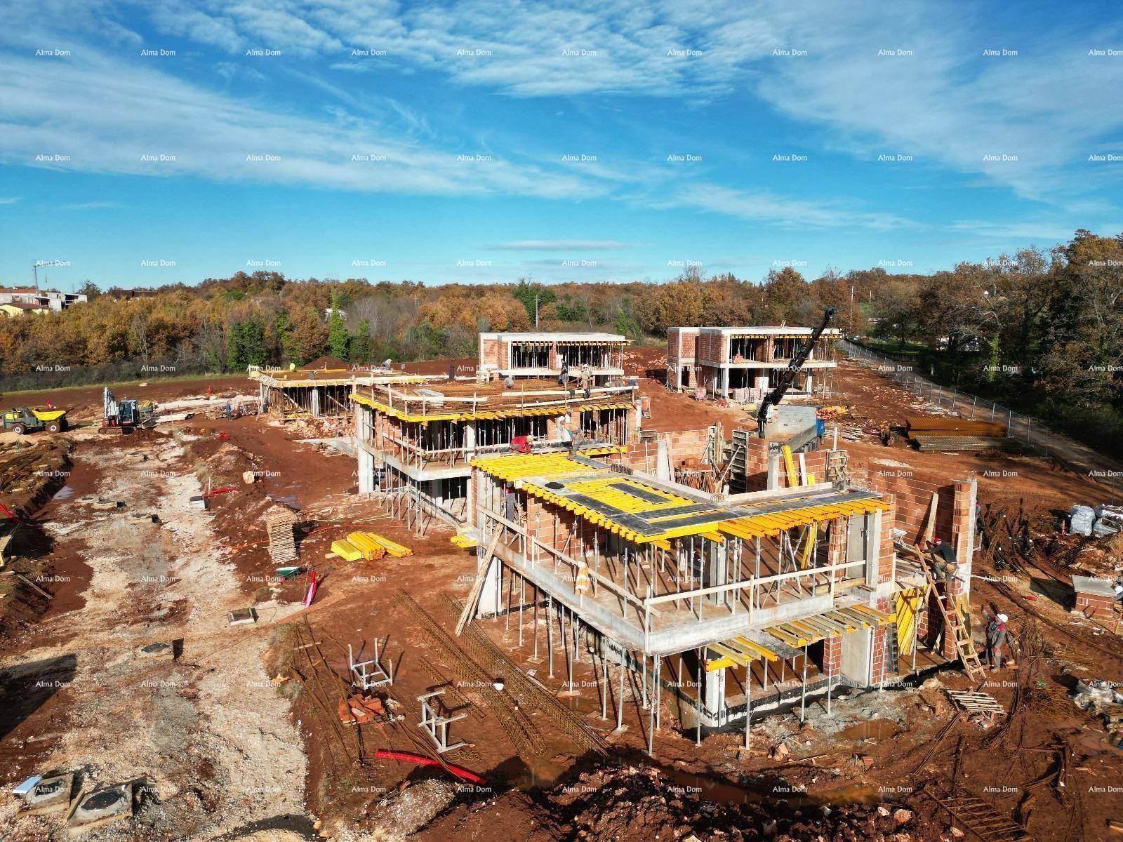 Luftaufnahme einer Baustelle mit mehreren im Bau befindlichen Häusern und Gerüsten.
