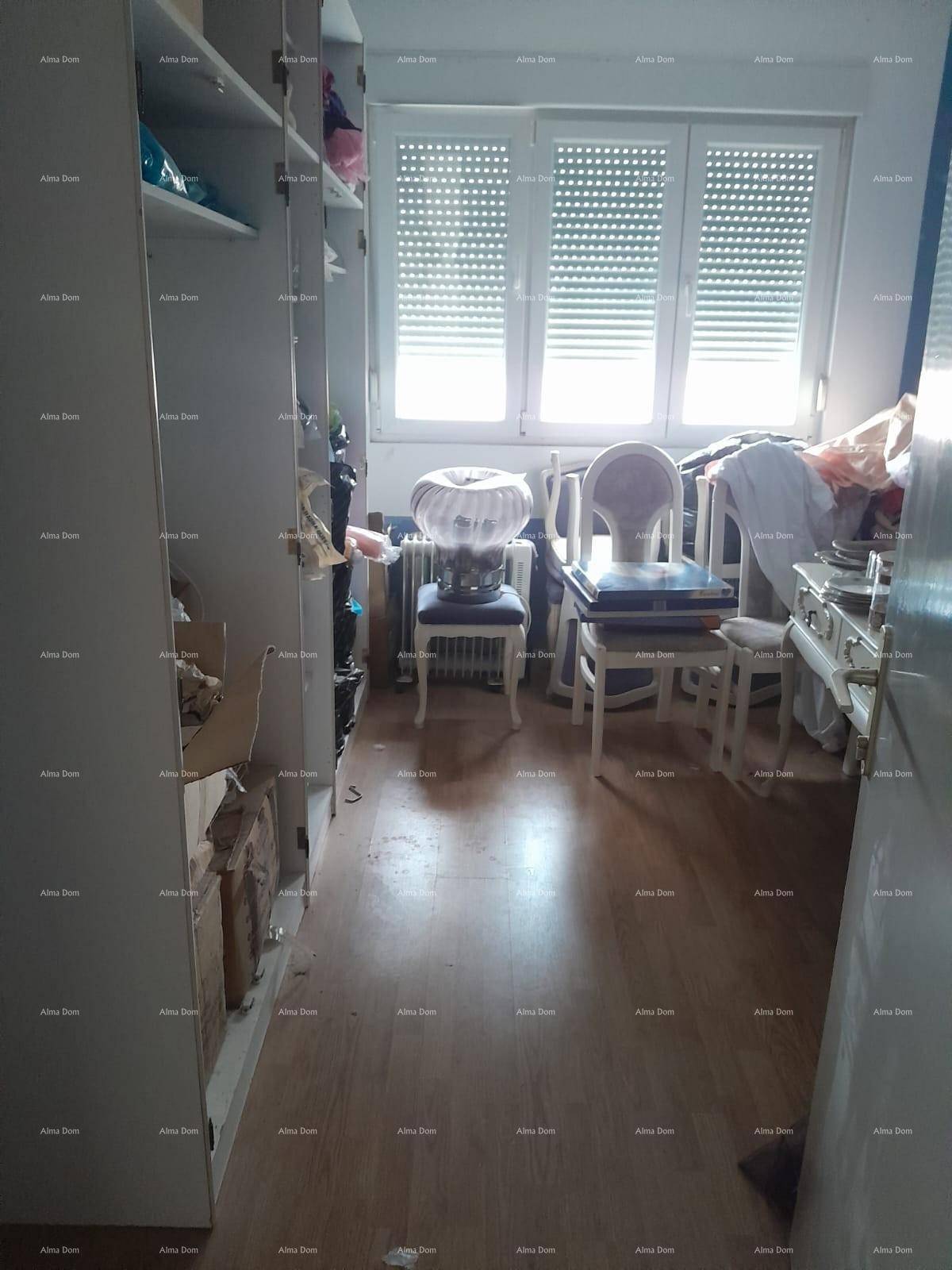 Abstellraum mit Regalen, einem Fenster mit Rollläden und verschiedenen gelagerten Gegenständen.