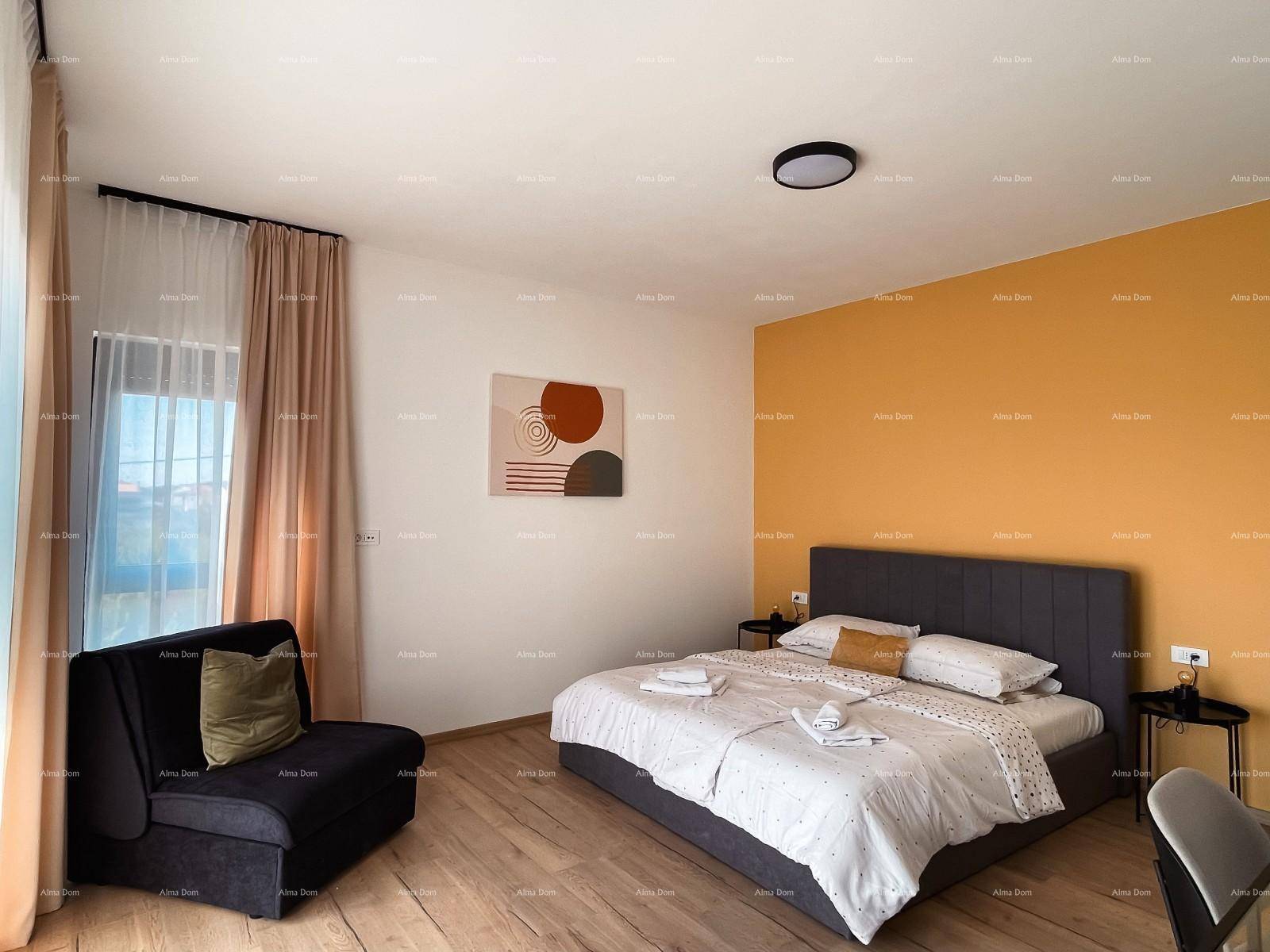 Helles Schlafzimmer mit Doppelbett, gelber Akzentwand und modernem Holzboden, inklusive Sitzgelegenheit.