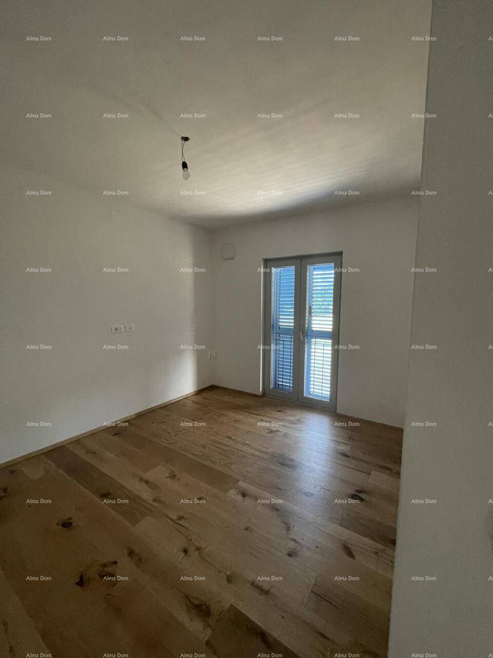 Helles Schlafzimmer mit Holzboden und Zugang zu einem französischen Balkon, ideal für Ruhe.