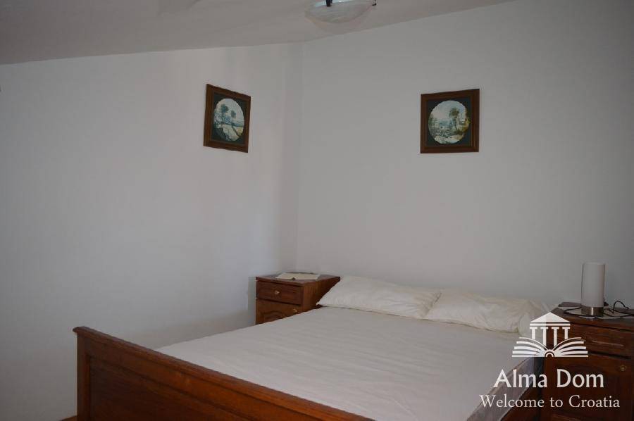 Einfaches Schlafzimmer mit Doppelbett und Nachttischen, ideal für Gäste oder Kinder.