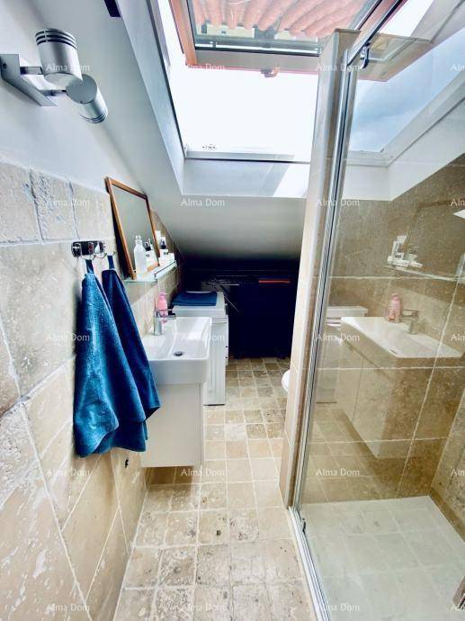 Modernes Badezimmer mit Waschbecken, Duschkabine und Dachfenster unter der Dachschräge.