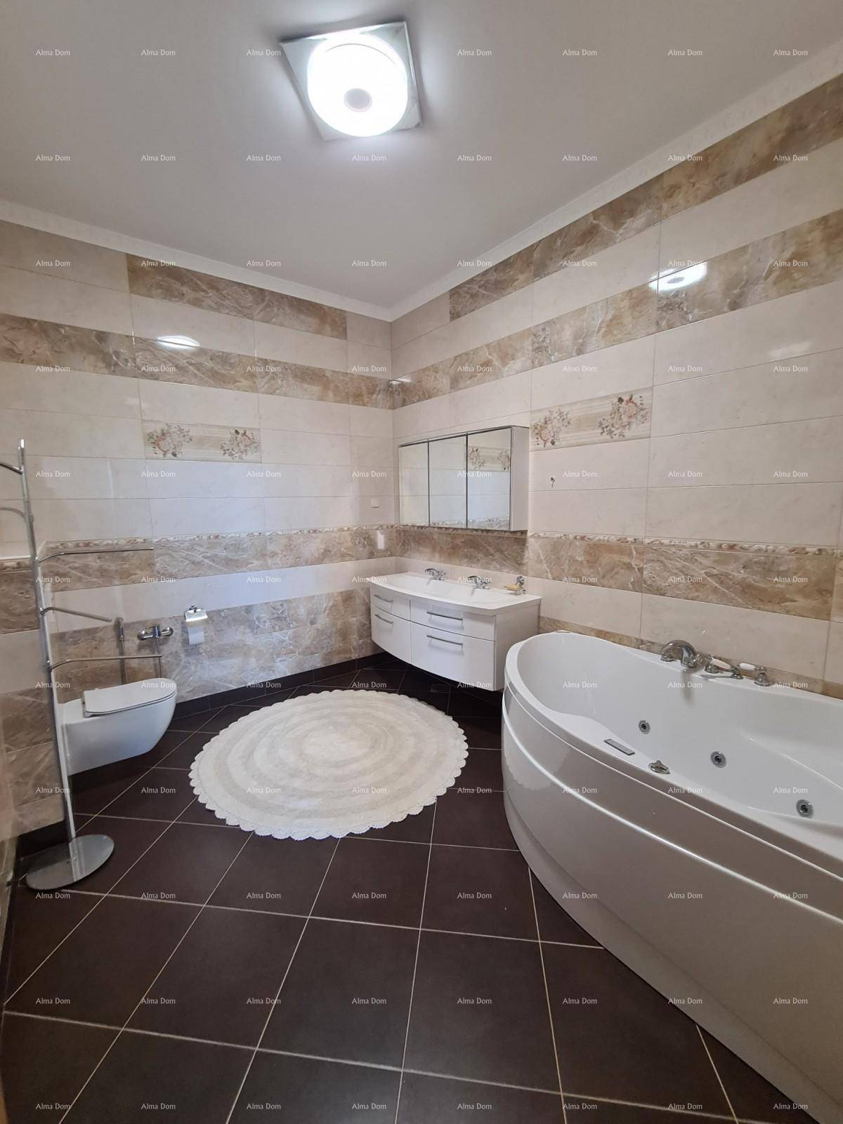 Geräumiges Badezimmer mit Whirlpool-Badewanne, Doppelwaschbecken und eleganten Wandfliesen.
