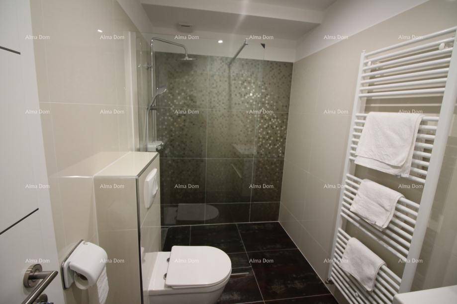 Helles Badezimmer mit Dusche, wandhängendem WC und beheiztem Handtuchhalter.