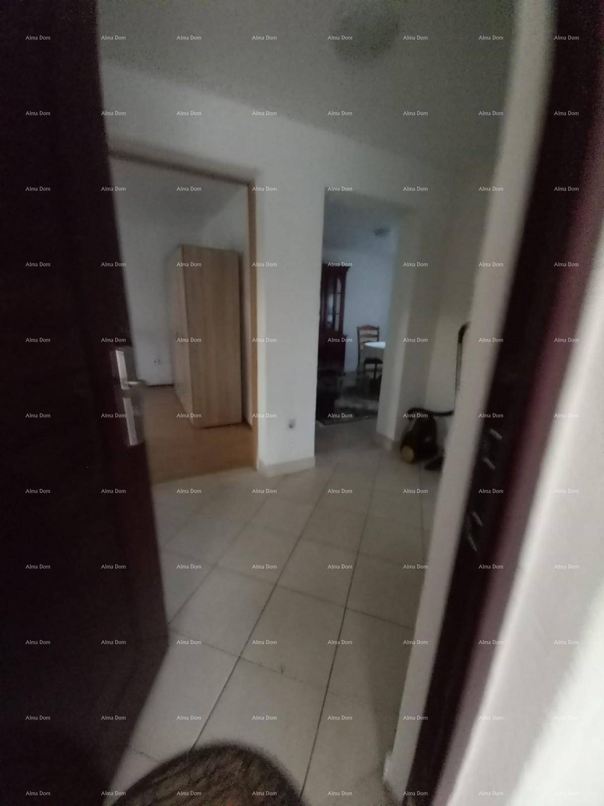 Flur mit Fliesenboden, der zu weiteren Räumen führt, mit einem Schrank im Hintergrund.